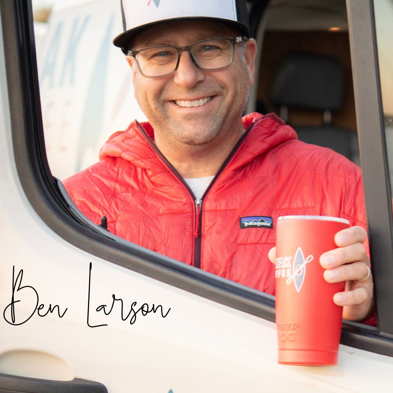 
                  
                    Ben Larson, owner of Kayak Coffee, in a red jacket holding a red Kayak Coffee cup, sitting inside the Kayak Coffee van.
                  
                